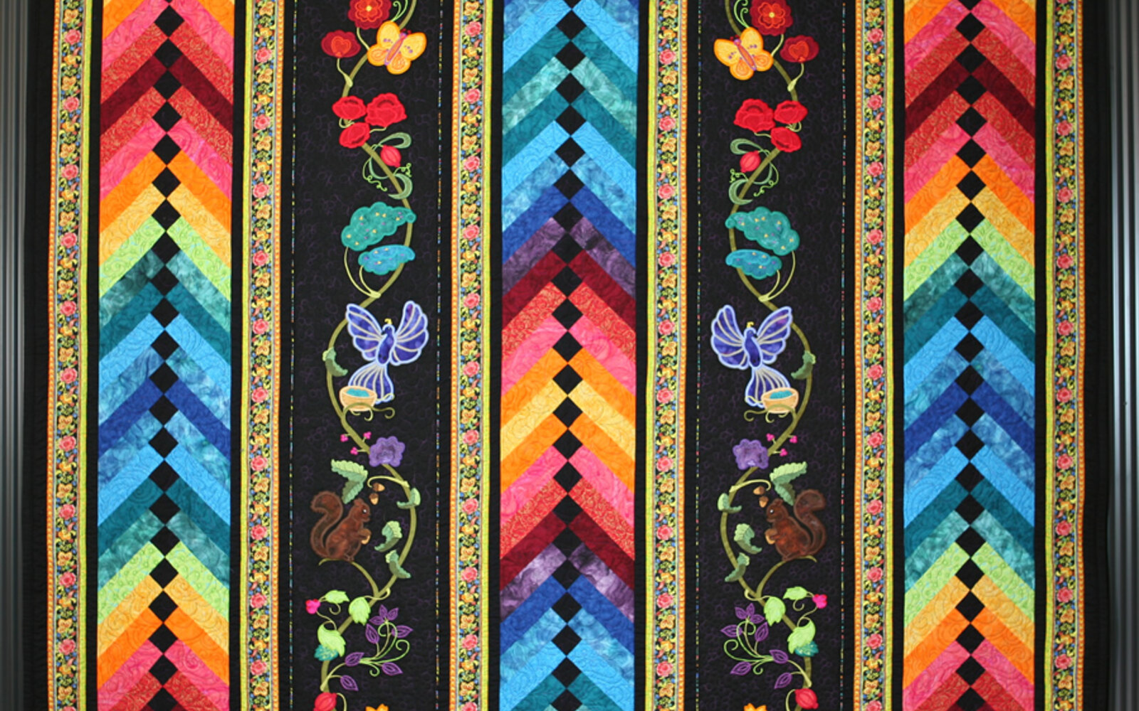 Colourful braid quilt with appliqued flowers, butterflies, and birds